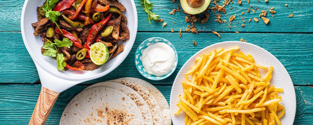Fajitas de vită cu ceapă, ardei și smântână și cartofi prăjiți subțiri